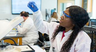 Image of a student in a laboratory looking at a sample.