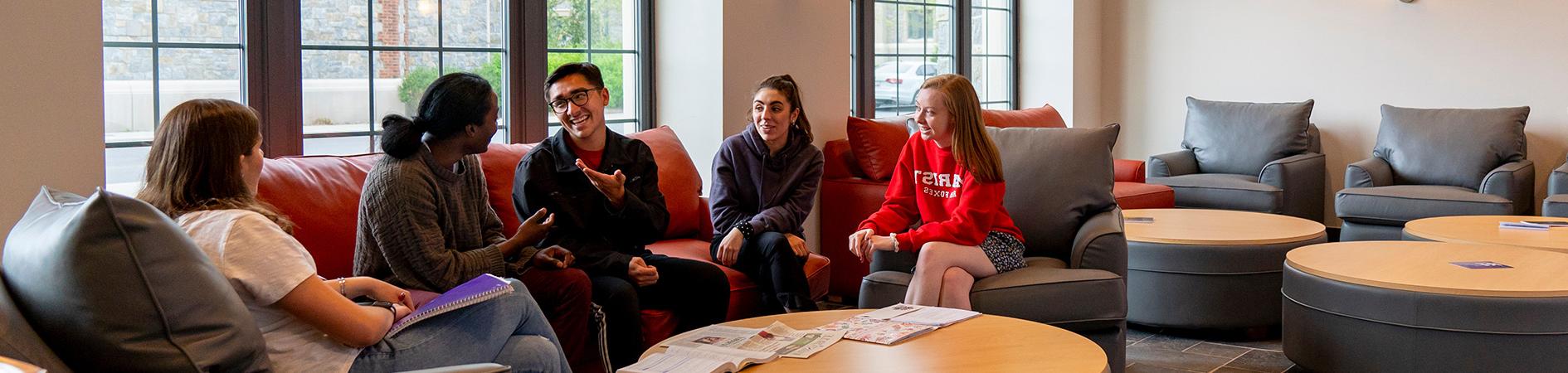 Photo of students socializing in residence hall lounge area